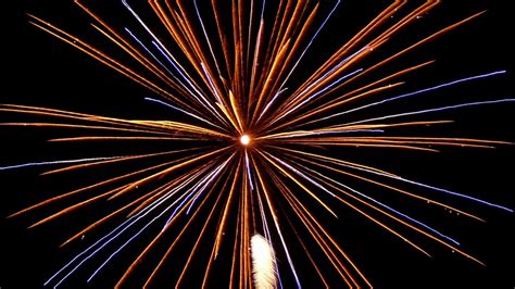 Download Wallpaper 1366x768 Fireworks Sparks Darkness Holiday Rays