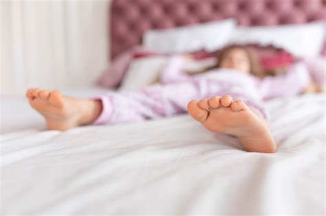 Feet Of A Girl Sleeping In A Comfortable Bed Focus On The Foot Stock