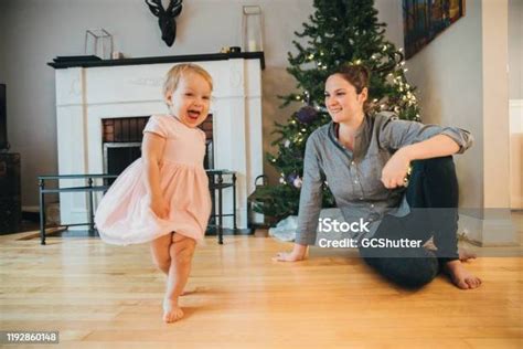 Playful Baby Girl Dancing While Mommy Admires The Little Angel Stock
