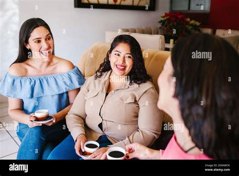 Latin Women Friends Hanging Out And Drinking Coffee In Home In Mexico