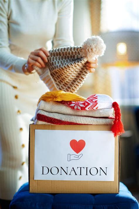 Closeup On Trendy Female Packing Donation Box With Clothes Stock Image