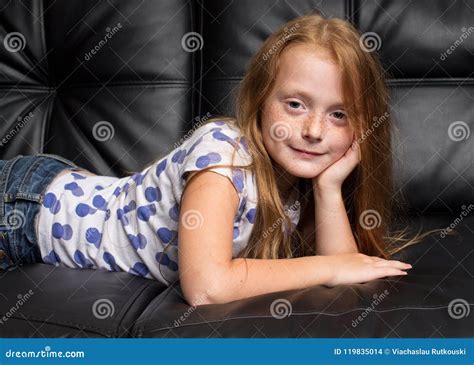Petite Fille Rousse Avec Des Taches De Rousseur Se Reposant Sur Le Sofa