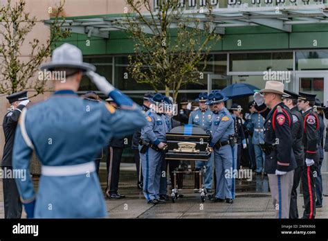 Washington State Patrol troopers accompany the casket of their fallen