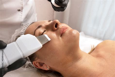 procedure with ultrasonic skin scrubber woman face scrubber treatment with ultrasonic spatula