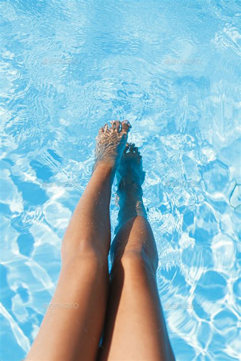 Beautiful Tanned Woman Legs Relaxing In Pool Water Enjoying Summer