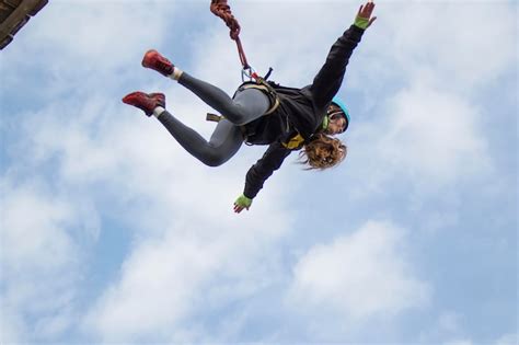 위험한 취미 하늘을 배경으로 다리에서 뛰어내리는 용감한 여자 프리미엄 사진