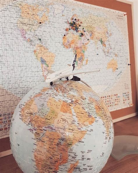 An Airplane Is Sitting On Top Of A Puzzle Ball With The World Map In The Background