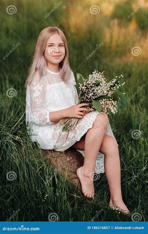 A Beautiful Nine Year Old Blonde Girl With Long Hair In A Long White