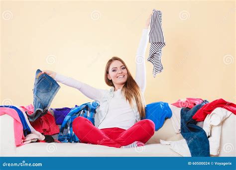 Happy Woman Sitting On Sofa In Messy Room At Home Stock Photo Image