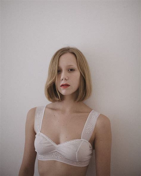 A Woman Wearing A Bra Posing In Front Of A White Wall