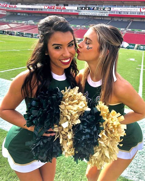 Two Cheerleaders Kissing Each Other On The Field