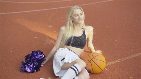 Cheerleader Sitting On The Floor With Legs Spread And A Basketball