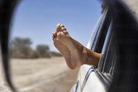 Womans Feet Leaning Out Of The Car Window Stockphoto