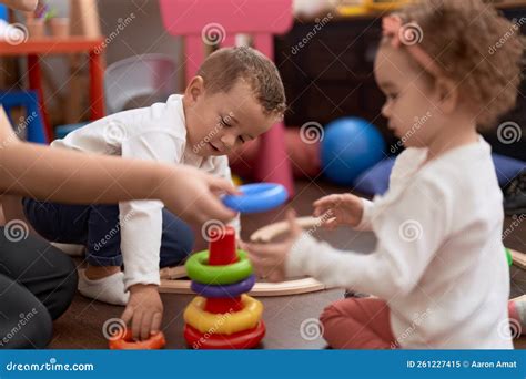 Adorable Girl And Boy Playing With Hoops Sitting On Floor At