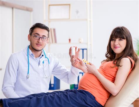 Pregnant Woman With Her Husband Visiting The Doctor In Clinic Stock Image Image Of