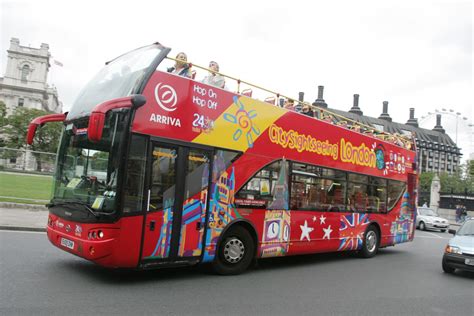 Guides and audio commentaries on the tour buses. The Original London Bus Company with tourists and a guide ...