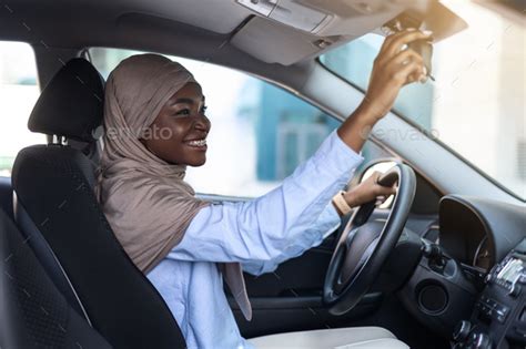 Buying New Car Muslim African Lady In Hijab Adjusting Rear View Mirror