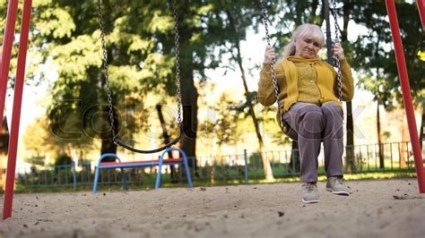 Lonely Sad Old Woman Riding On Swing In Stock Image Colourbox