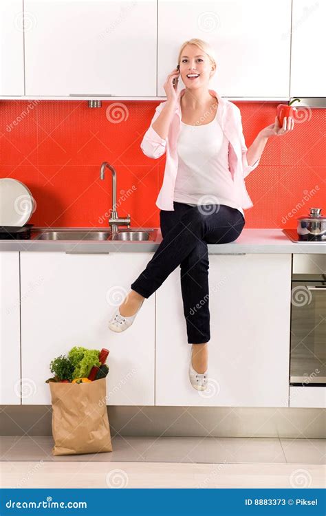Woman Sitting On Counter In Kitchen Stock Image Image Of Food Jeans