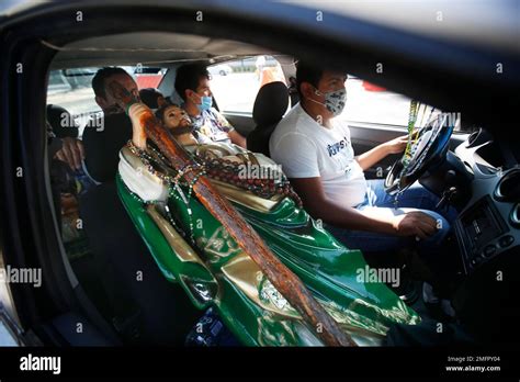 A Saint Jude statue is transported in the passenger seat of a car