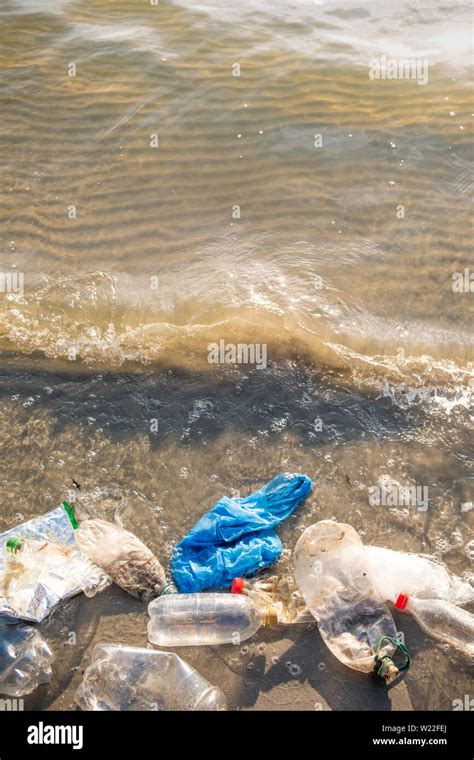 Plastic Bag And Bottles On The Beach Seashore And Water Pollution Concept Trash Empty Food