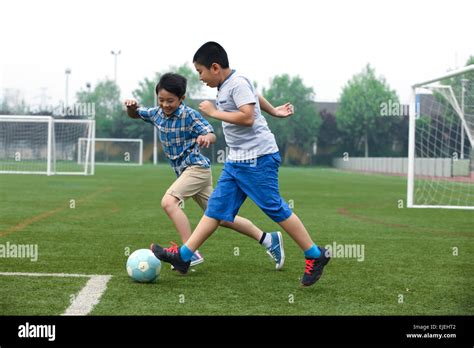 Two Boys Are Playing Football On The Football Field Stock Photo Alamy
