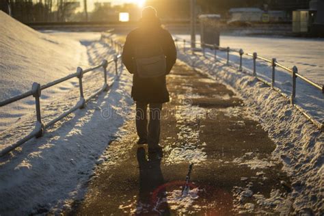 Man Walks Down Road Into Sunset Sun Is Setting Pedestrian In Winter