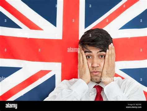 Portrait Of A Shocked Indian Man With Hands On Cheeks Against British