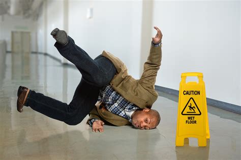 African American Businessman Falling On Wet Floor In Office Toilet