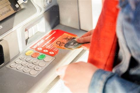 Best for a higher potential credit line. Image of Woman withdrawing cash from ATM - Austockphoto