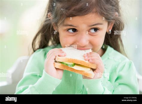 Little Girl Eating Sandwich At Home Stock Photo Alamy