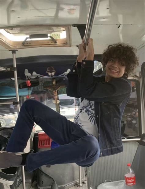 A Man Hanging Upside Down On A Bus With His Feet In The Air And Smiling