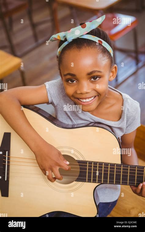 Little Girl Playing Guitar In Classroom Stock Photo Alamy