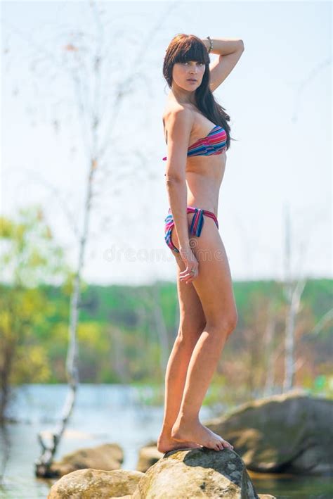 Slender Brunette Posing On A Large Rock Stock Image Image Of Elegance