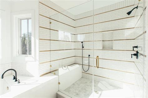 Our fave bathroom tile design ideas. White Shower Tiles with Brass Schluter Strips ...