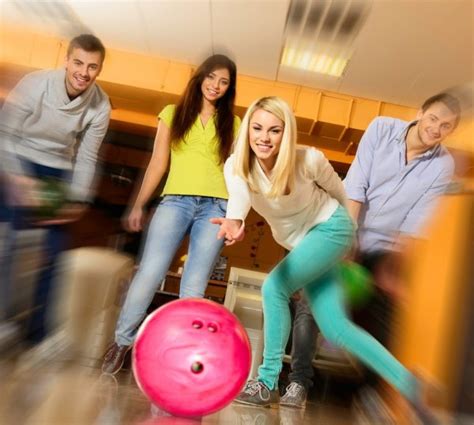 Group Of Four Young Smiling People Playing Bowling — Stock Photo