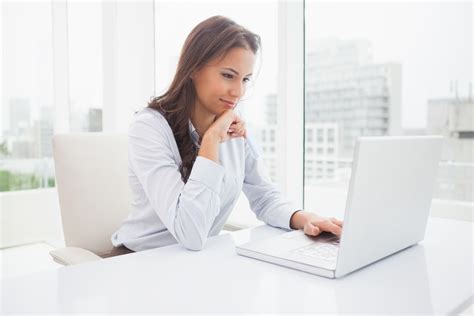 Happy Businesswoman Using Laptop At Her Desk Dominion Payroll