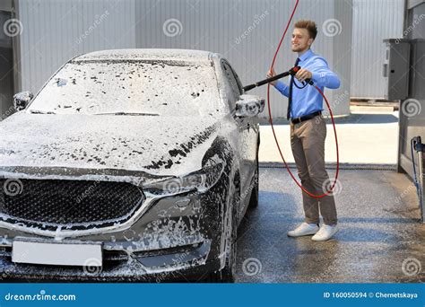 Businessman Cleaning Auto With High Pressure Water Jet Stock Photo