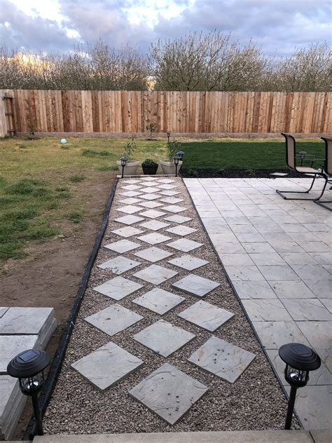 Backyard Pathway Designed With Diagonally Places Pavers And Pebble