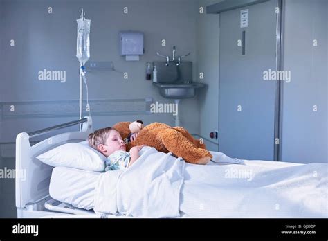 Chico Paciente En La Cama Abrazando A Teddy Bear En El Hospital