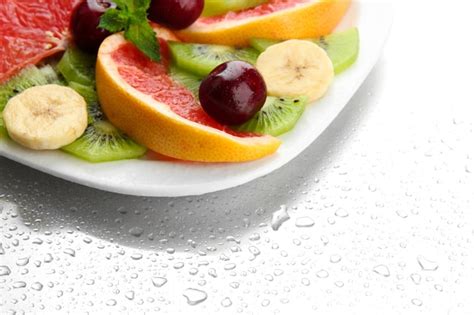 Premium Photo Assortment Of Sliced Fruits On Plate With Drops