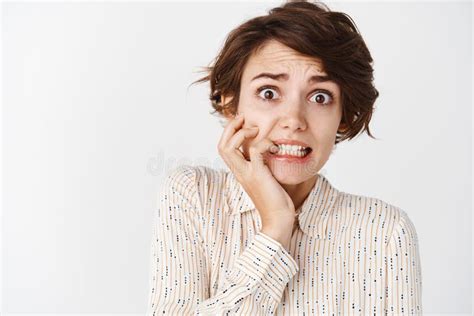 Close Up Of Anxious Brunette Girl Biting Fingernails And Looking