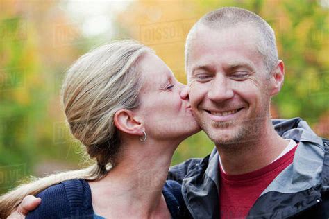 Wife Kissing Husband On The Cheek In A Park In Autumn Edmonton