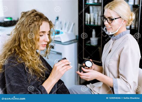consultation in cosmetology clinic female beauty doctor talking with woman patient and showing