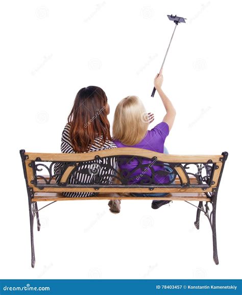 Back View Of Two Women To Make A Selfie Stick Portrait Sitting On The Bench Stock Image Image