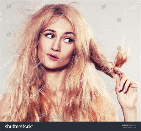 Young Woman Looking At Split Ends Damaged Long Hair Stock Photo