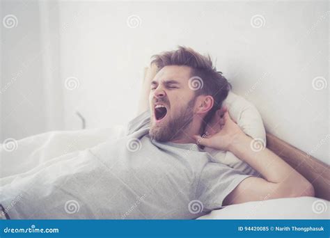 Handsome Young American Male Yawn Sleeping In Bed At Home Stock Image