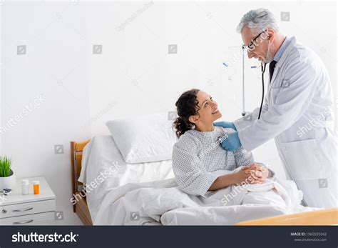 Doctor Examining Cheerful African American Woman Stock Photo 1960555942