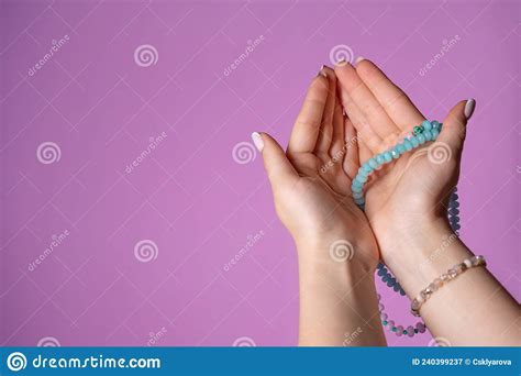 woman holds in hand rosary or mala beads strand used for keeping count during mantra meditations