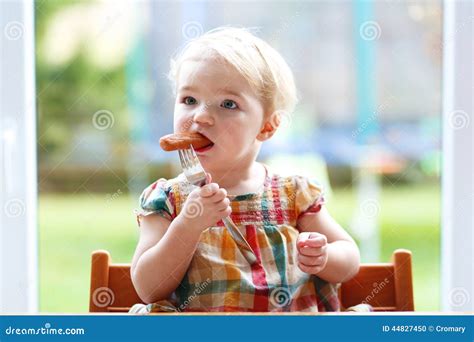 Cute Baby Girl Eating Sausage From Fork Stock Photo Image 44827450